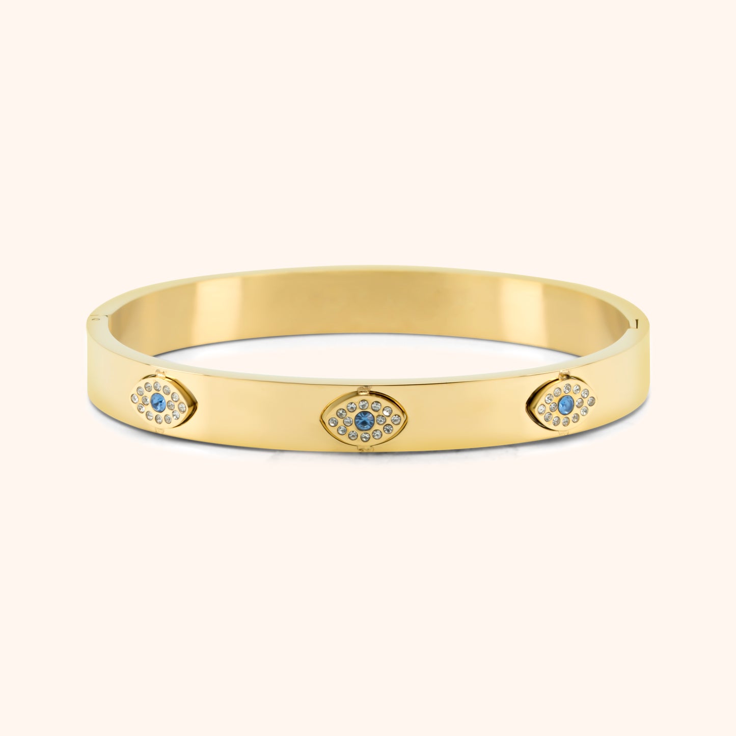 Gold bangle bracelet with three sparkling evil eye charms in blue and clear stones