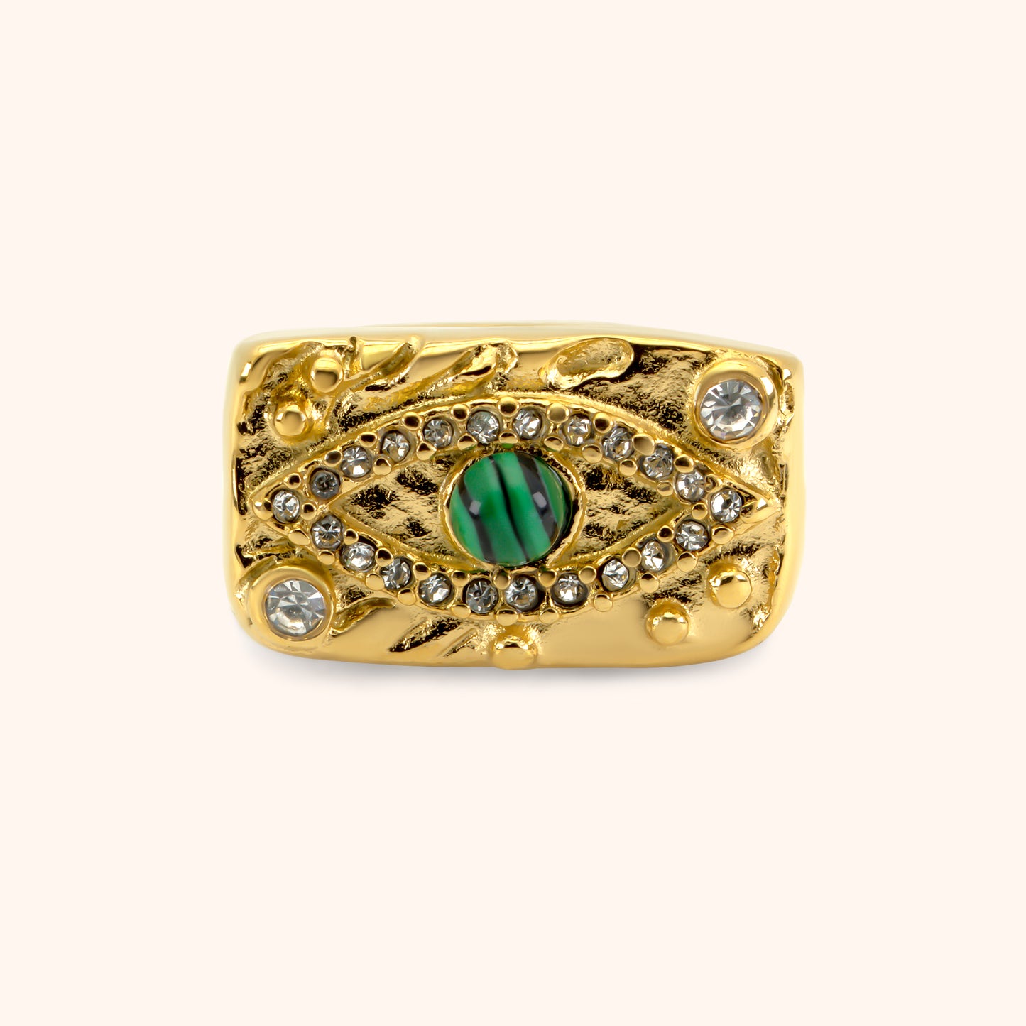 PRESSIE Sentinel Ring in 18k gold plate; front view of the rectangular face featuring an evil eye design with a central green patterned stone and surrounding clear pavé stone details on a textured gold background.