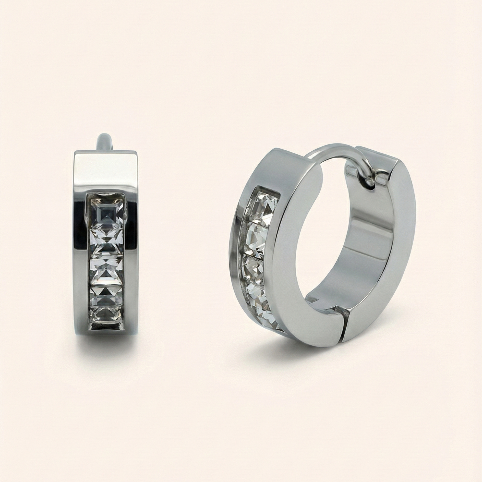 Pair of silver hoop earrings with embedded stones on a light beige background