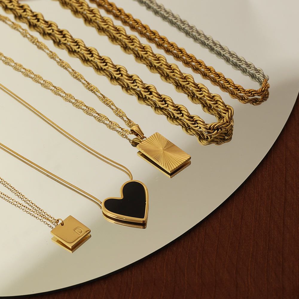 Close-up of rectangular pendant with sunburst design on 18K gold plated necklace