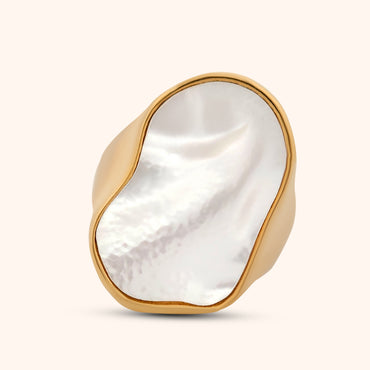 A hand wearing an abstract mother of pearl ring with a sleek gold band, demonstrating its modern and elegant style.