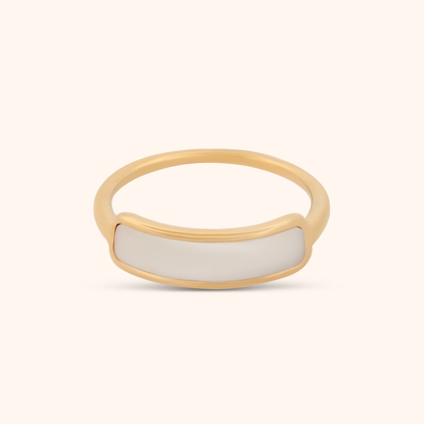 Close-up of a dainty gold ring with a slender band and a subtle strip of mother of pearl, showcasing its delicate and elegant design.
