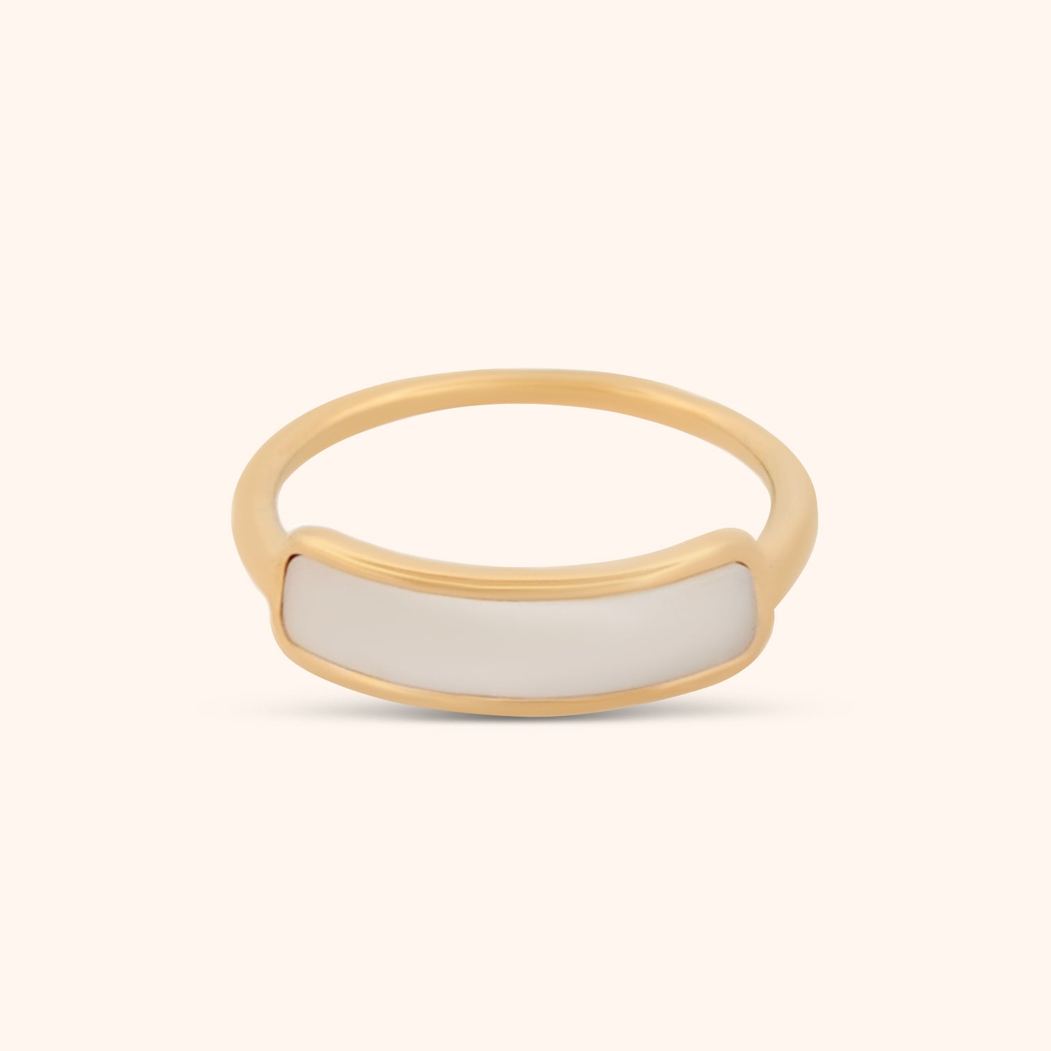 Close-up of a dainty gold ring with a slender band and a subtle strip of mother of pearl, showcasing its delicate and elegant design.

