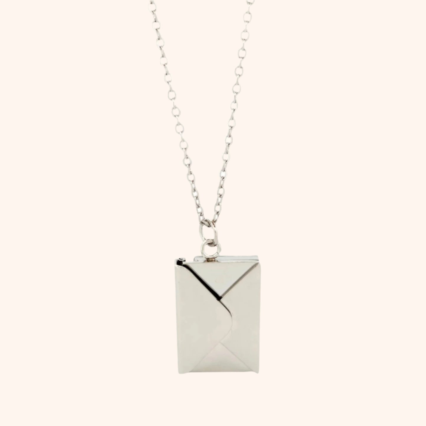 Close-up of a silver functional envelope necklace pendant, showcasing its detailed design and elegant style.
