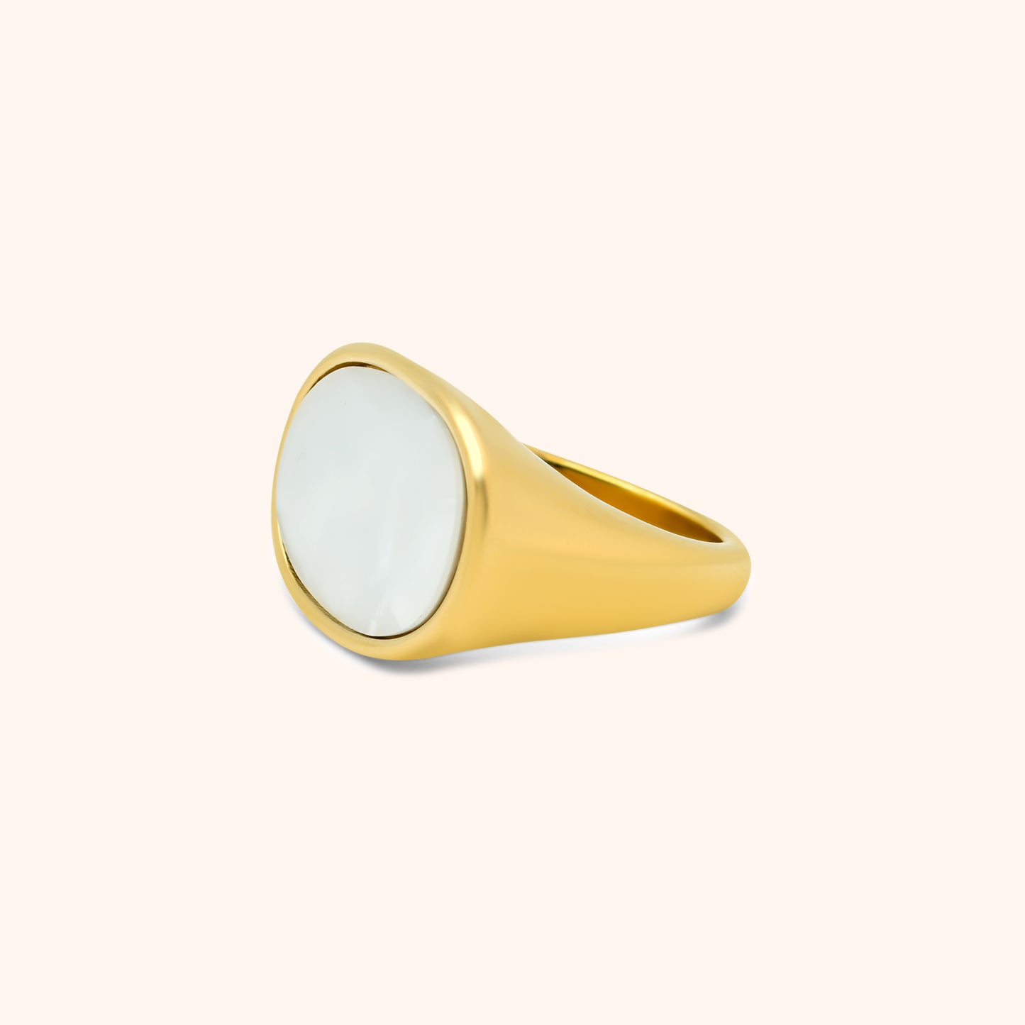 Side view of gold ring with smooth tapered band and glossy oval pearl face