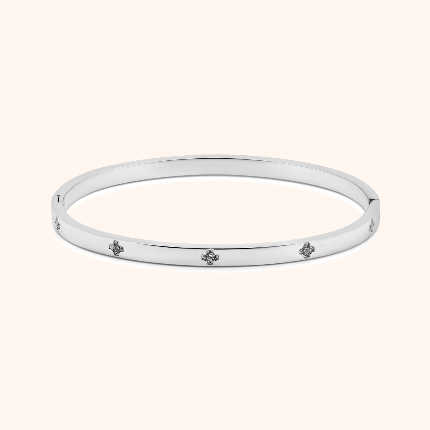 Silver clover bangle bracelet with crystal accents, flat lay