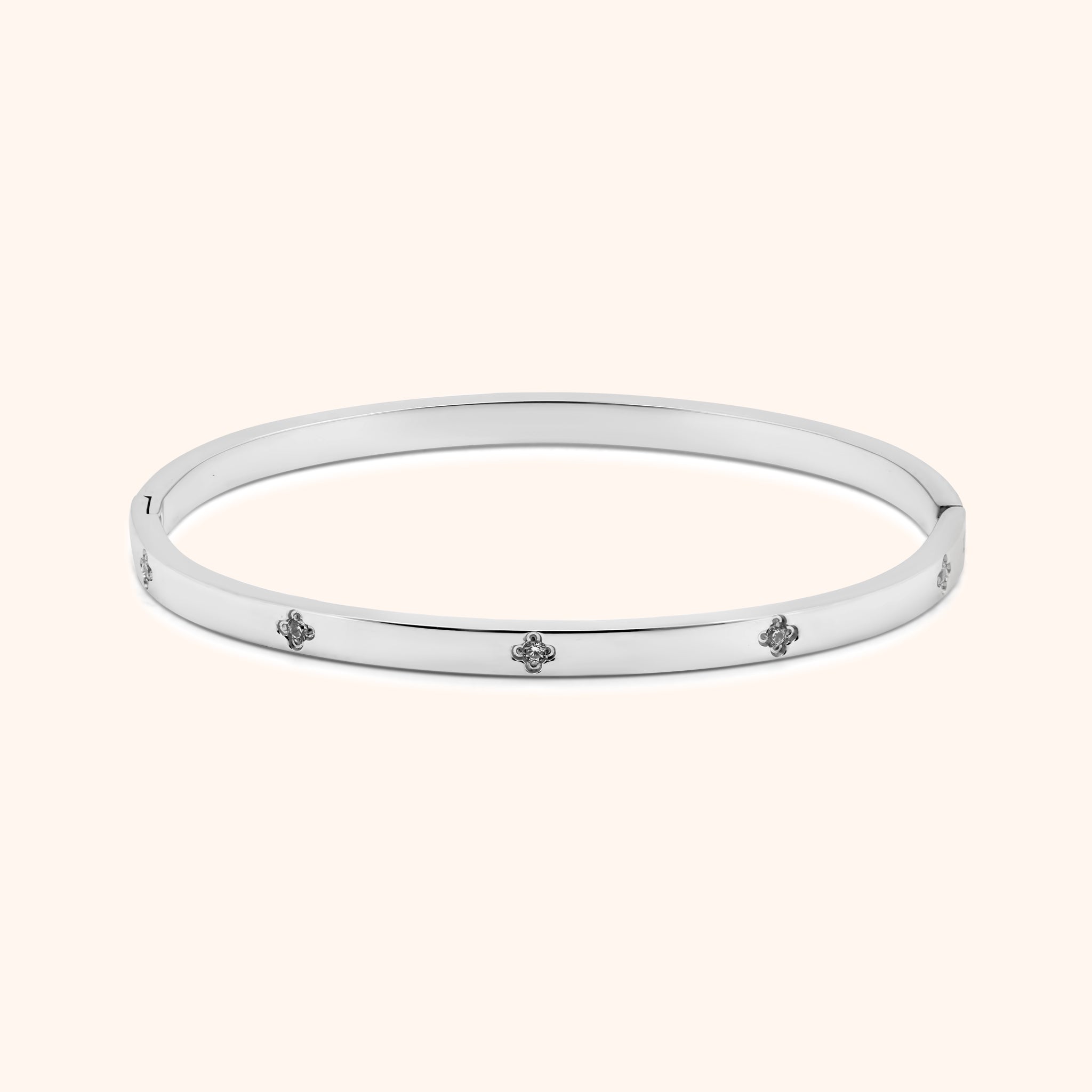 Silver clover bangle bracelet with crystal accents, flat lay