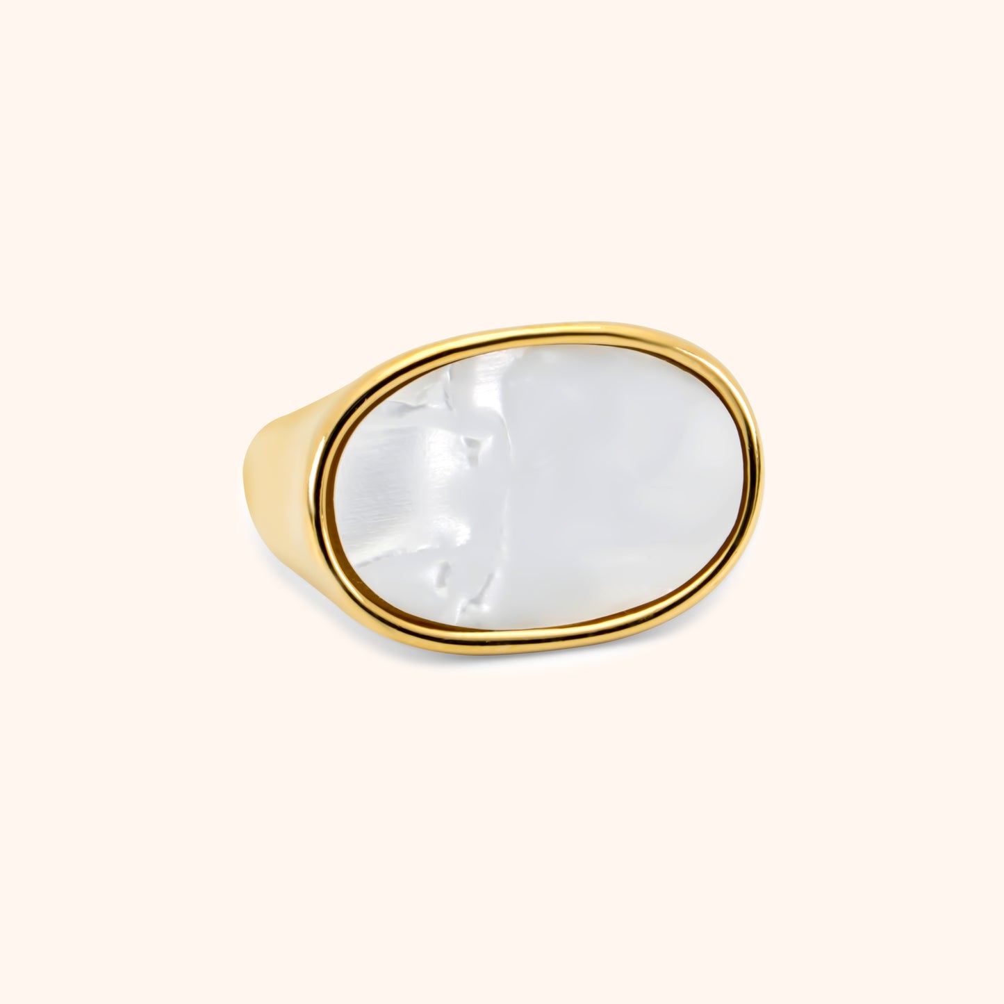 Gold signet-style ring with large oval mother-of-pearl inlay, viewed from front angle