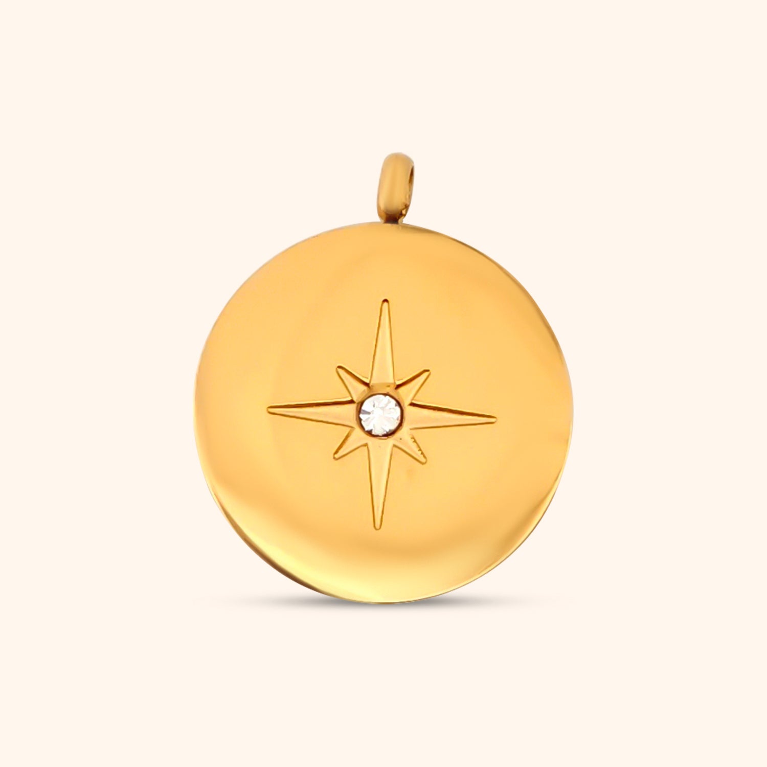 Close-up of the Stella Charm, a circular gold charm featuring a North Star design.