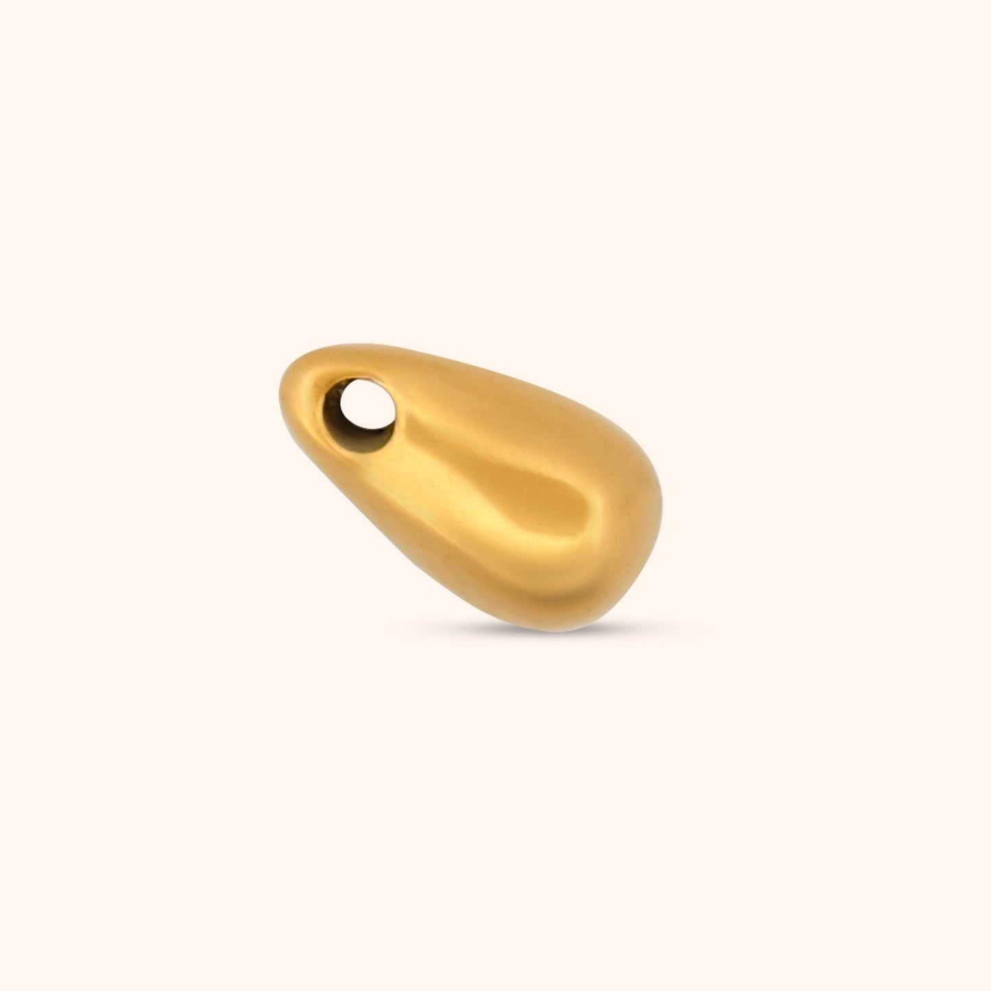 Close-up of the Cascade Charm, a gold teardrop-shaped charm with a threader design.