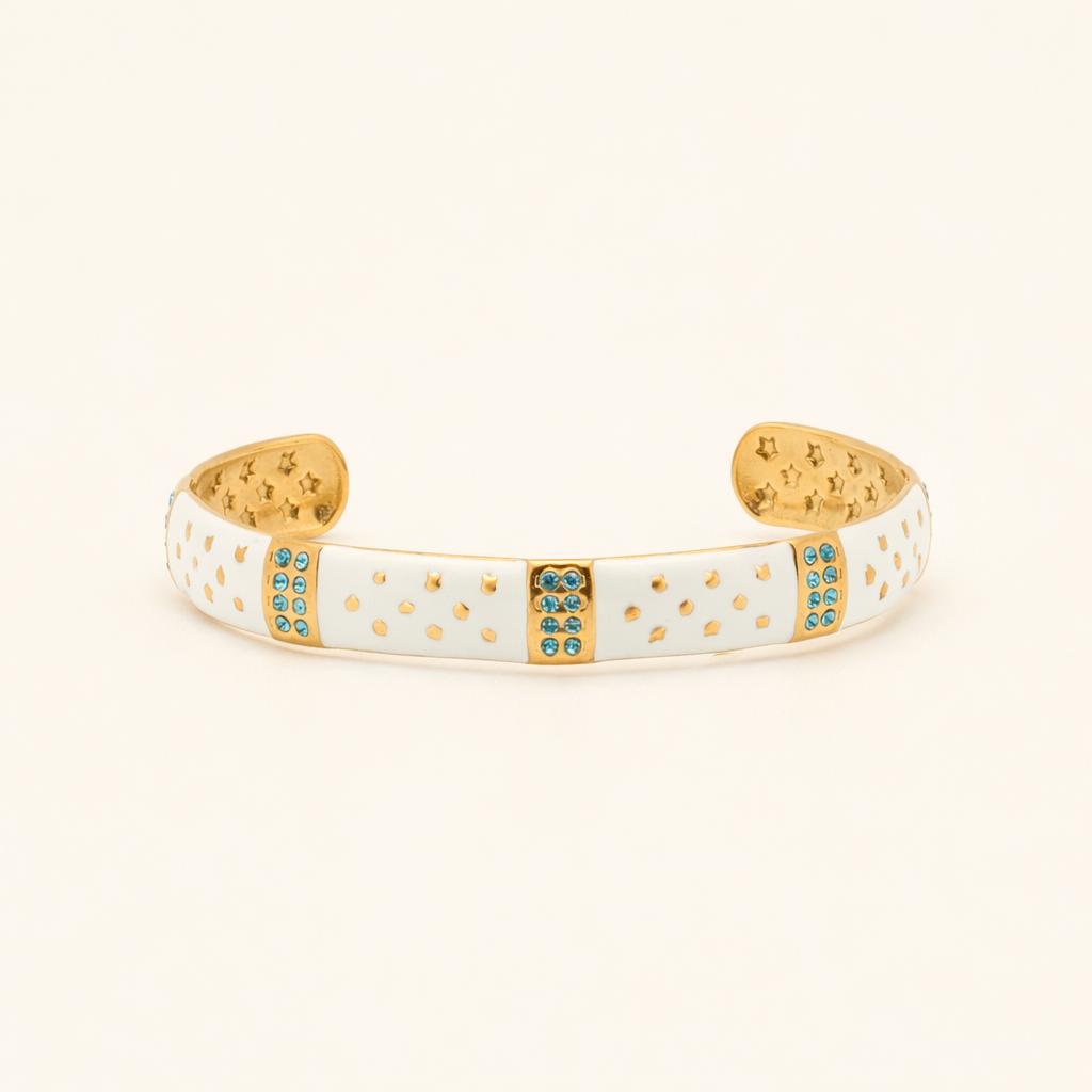 Gold and white bracelet with blue stones on a beige background