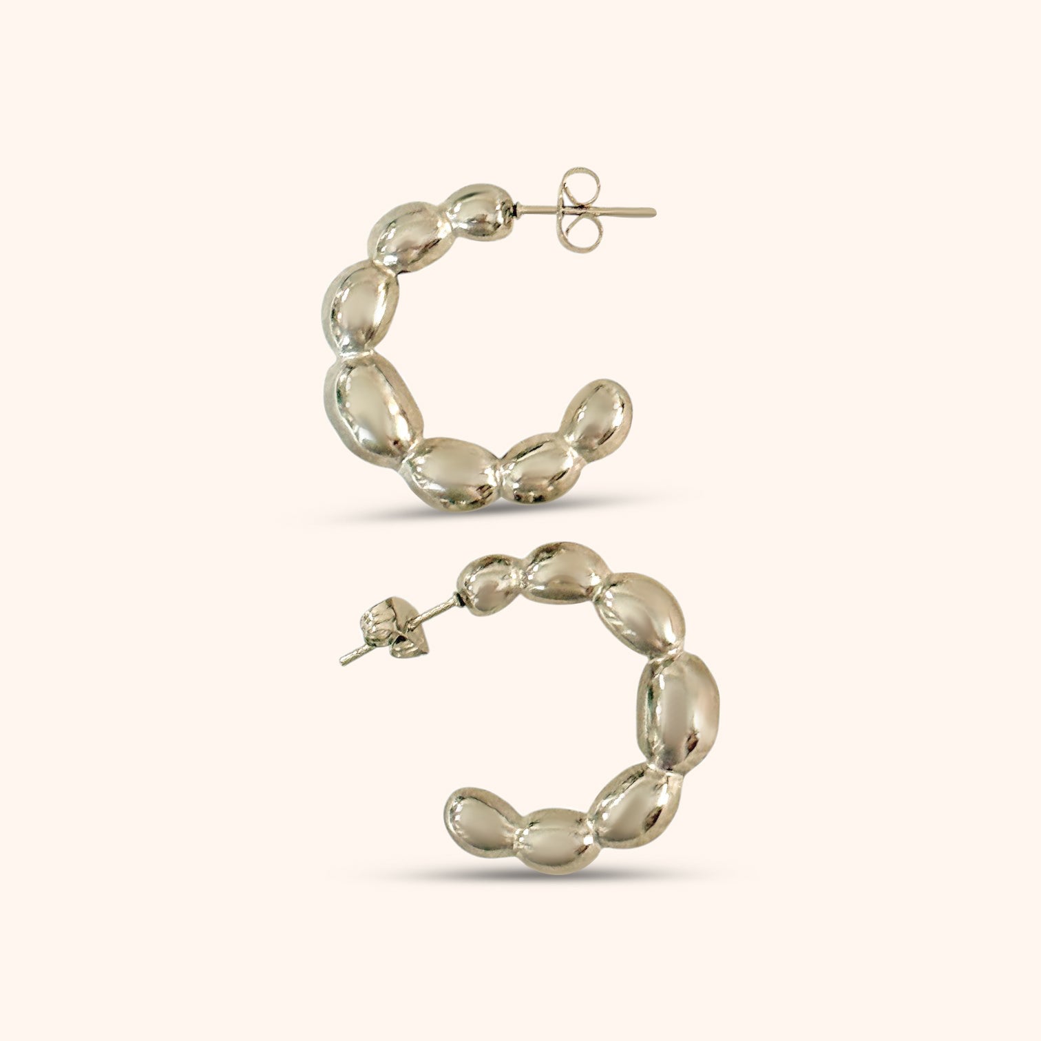 Detailed view of gold balloon hoop earrings showcasing their bold, contemporary design and polished finish