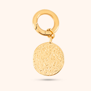 Angled view of the Luna Charm, a gold charm with a detailed moon and star design, showcasing the pearls, cubic zirconia accents, and small hoop for attachment.