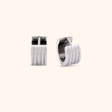 Pair of gold ribbed huggie earrings, highlighting their elegant and modern style.

