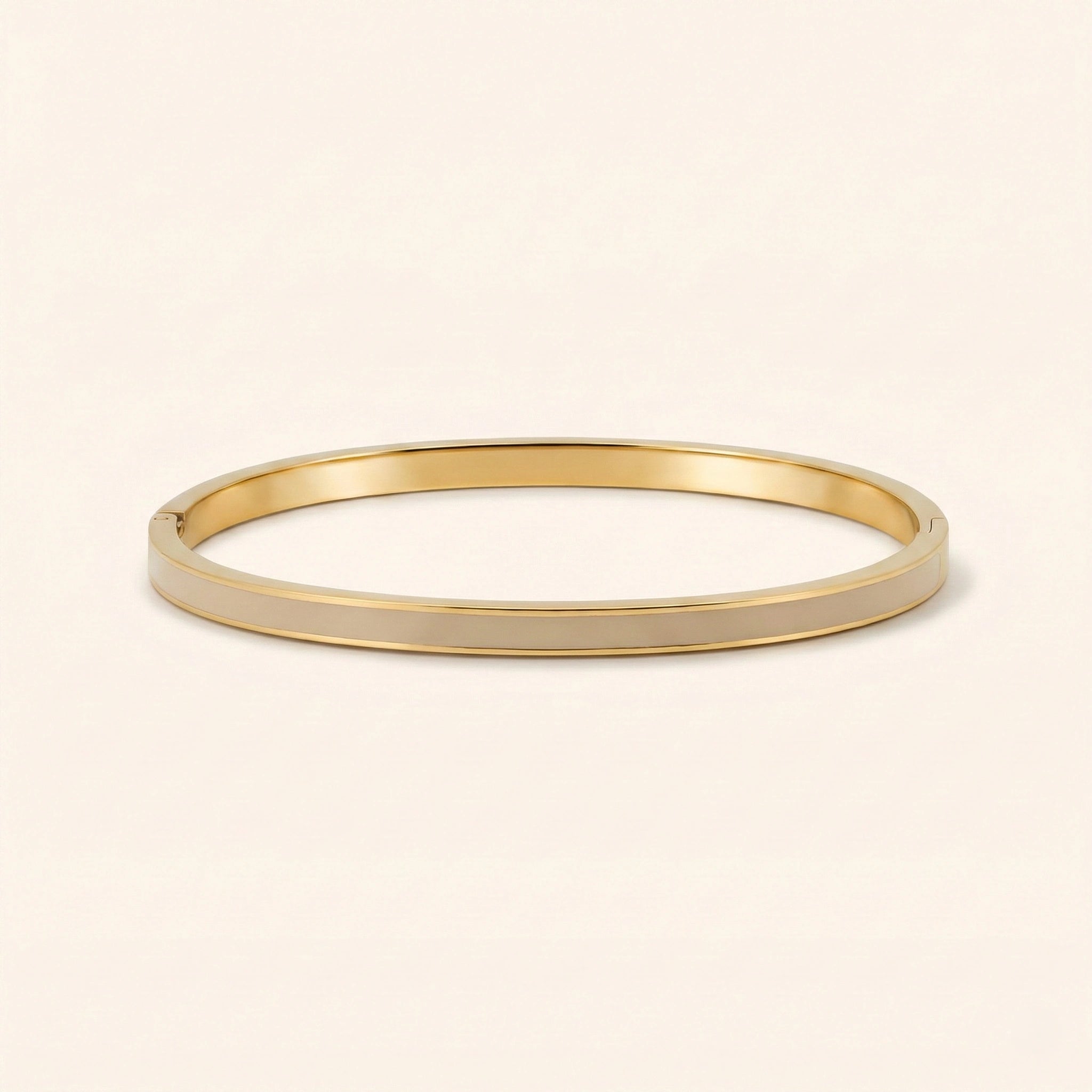 Gold bangle on a beige background