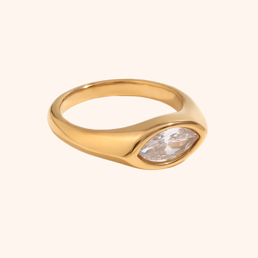 Gold ring with a clear gemstone on a white background