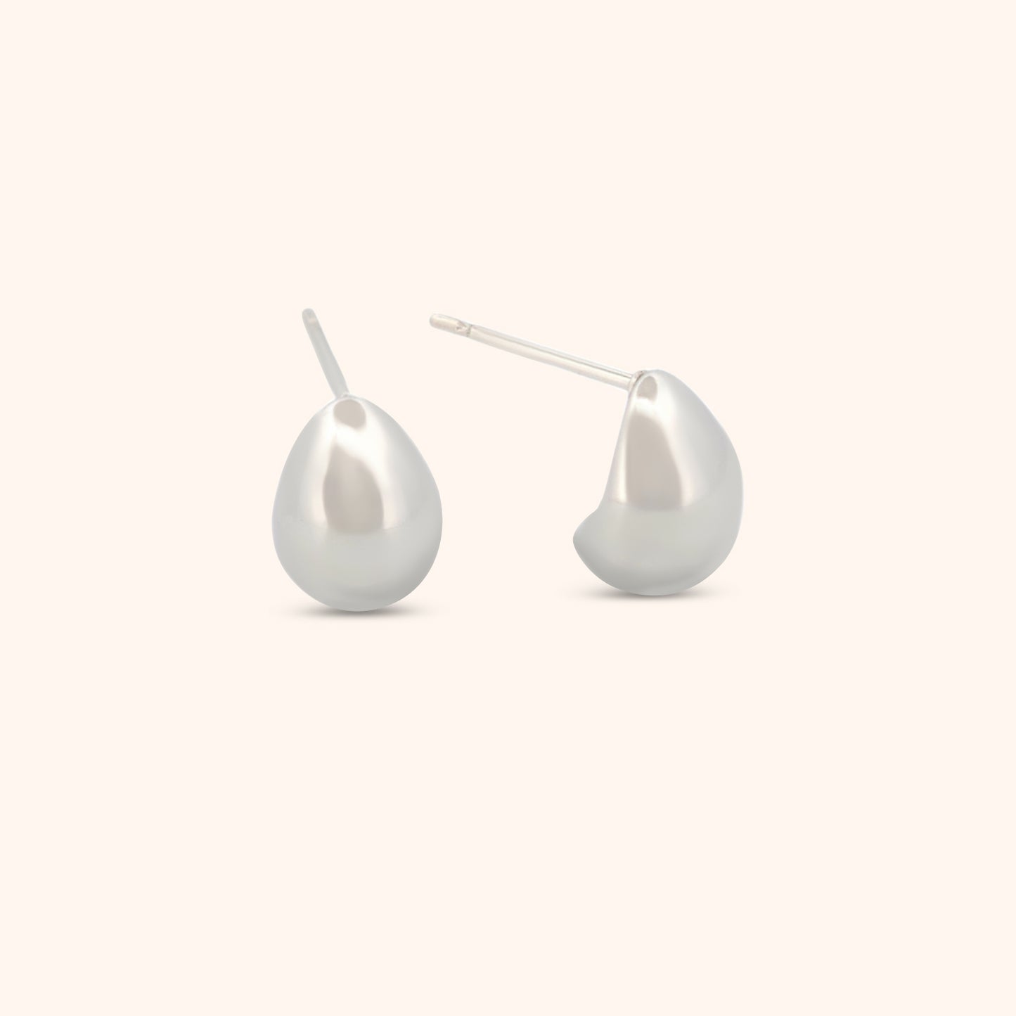 Detailed view of silver teardrop earrings, highlighting their minimalist elegance and sleek, teardrop shape.