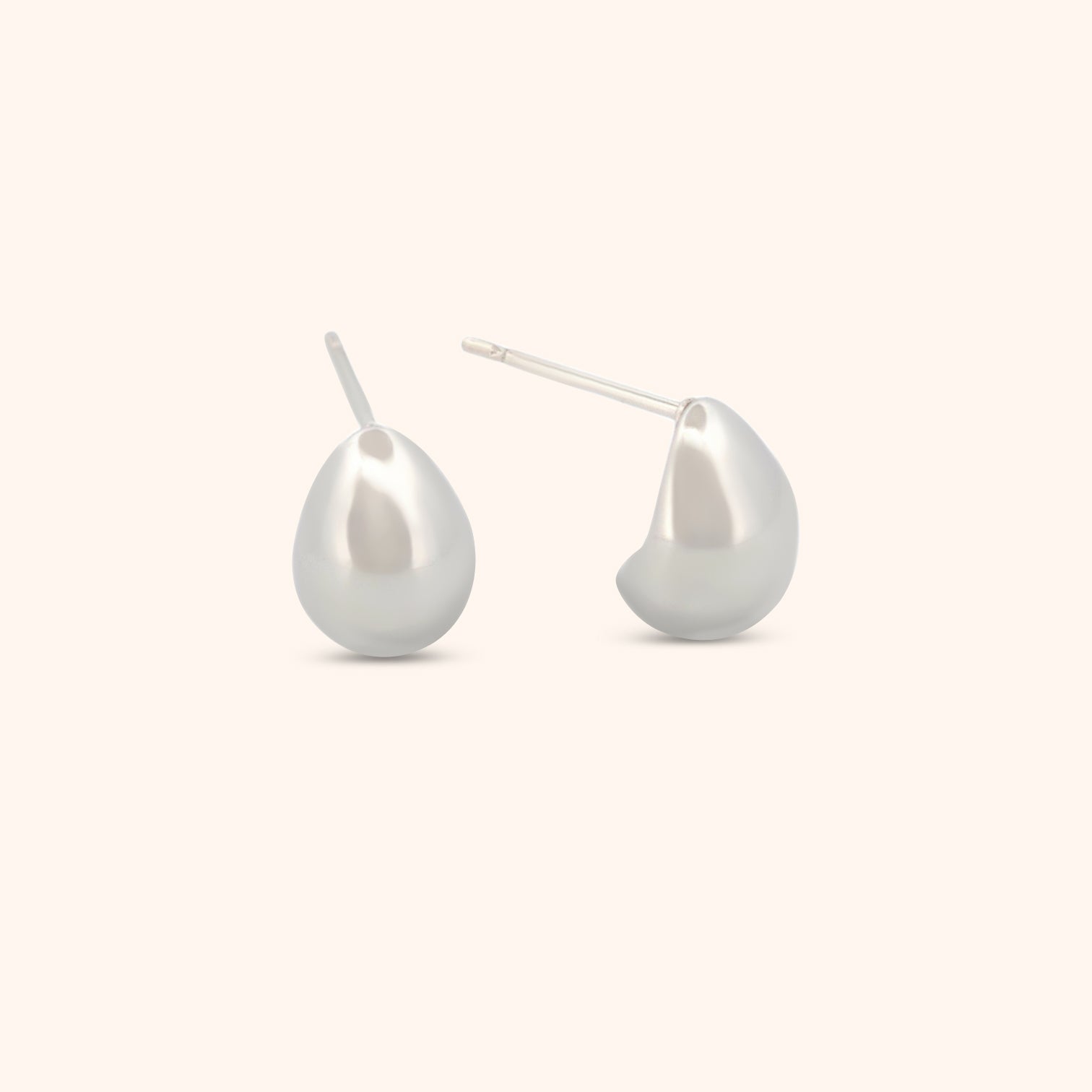 Detailed view of silver teardrop earrings, highlighting their minimalist elegance and sleek, teardrop shape.