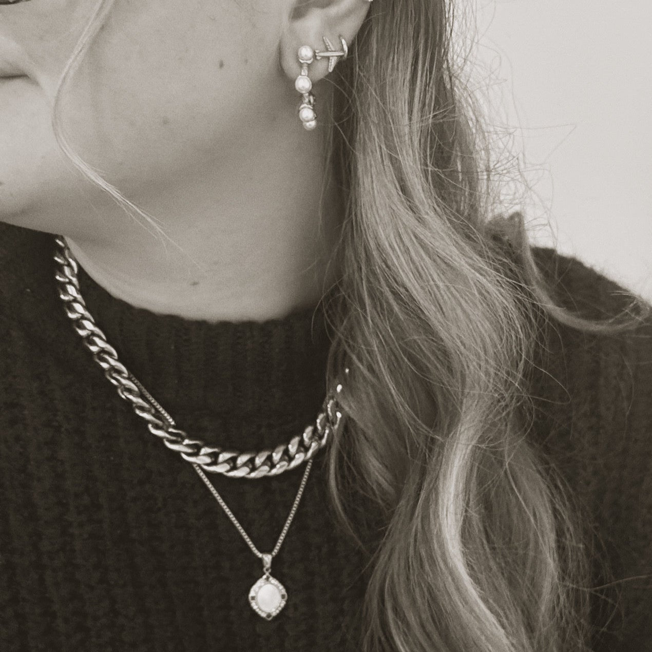 The Voyage Pendant Necklace, a gold necklace with a geometric pendant, worn on a person to demonstrate its size and style